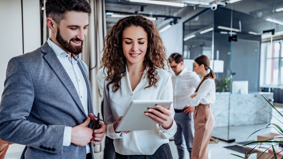 Two coworkers looking at a tablet in the office