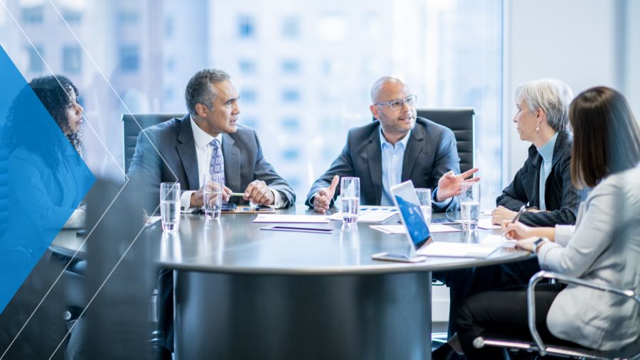 Corporate business team meets in office to discuss evolving treasury priorities they need their banks to meet.
