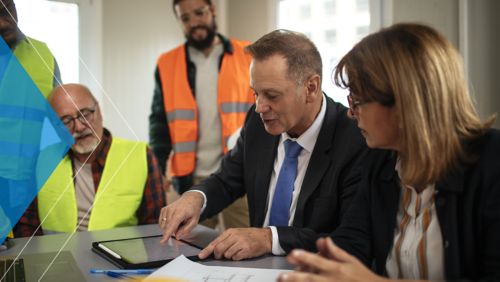 Mid-market AP construction team meeting on automation strategies in office. 