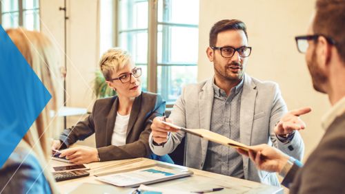 Receivables team meeting in office to assess ways to improve their AR efficiency. 