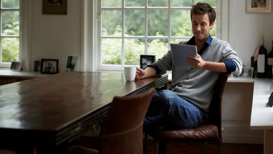 Man sitting at a table using a tablet