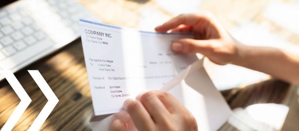 hands putting business check in window envelope
