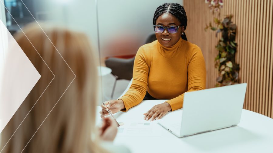 A woman sitting at a desk working on a laptop 