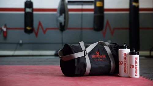 A gym bag and two water bottles with branded logos on them.