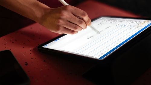 A person's hand using a tablet. 