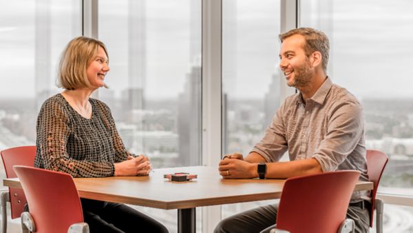 Two Deluxers discuss a project at a table