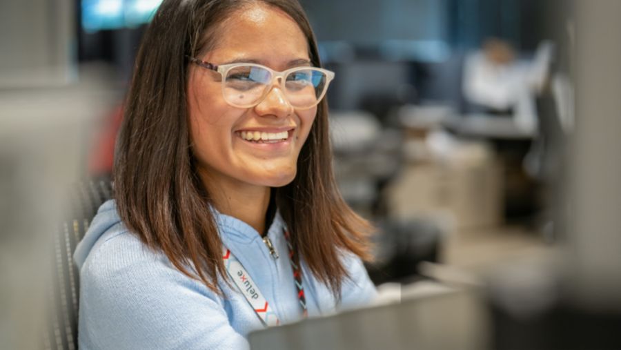 A Deluxer looks up from her laptop after having learned more about our company culture.