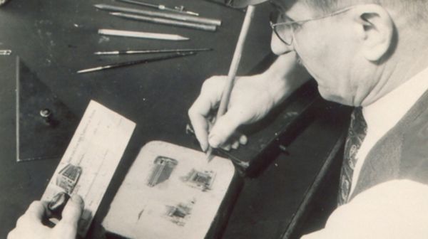 An early Deluxe worker edits details on a lithographic print plate.