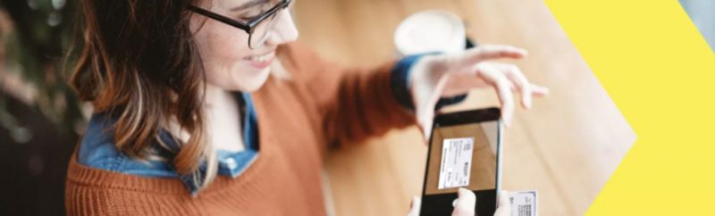 A woman uses a mobile phone to take a picture of a check