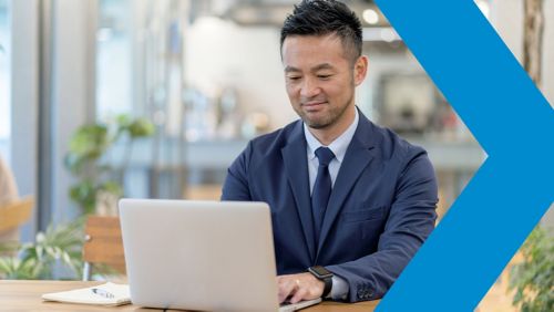 A financial marketer sits working at his laptop.