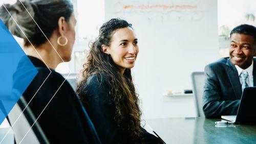 Three coworkers meeting in corporate office space. 