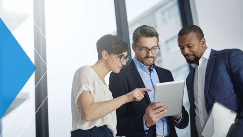 Coworkers grouped around a tablet reviewing information