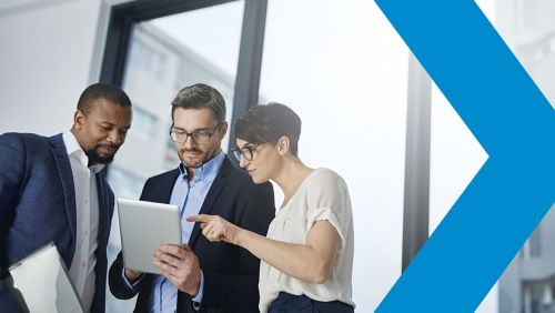 Coworkers grouped around a tablet reviewing information