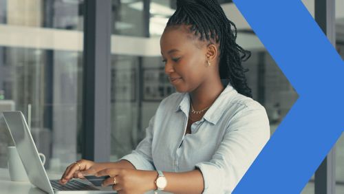 Woman working on laptop computer in office. 