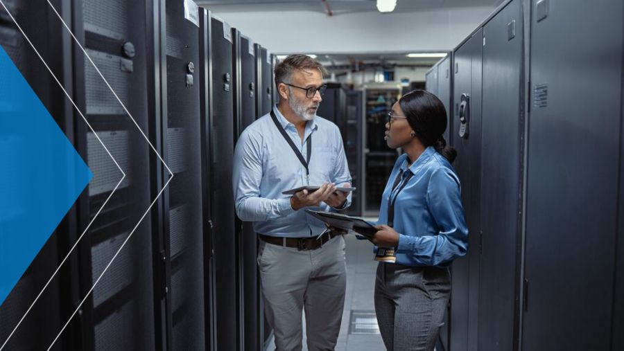 Two information security professionals having a discussion in a server room