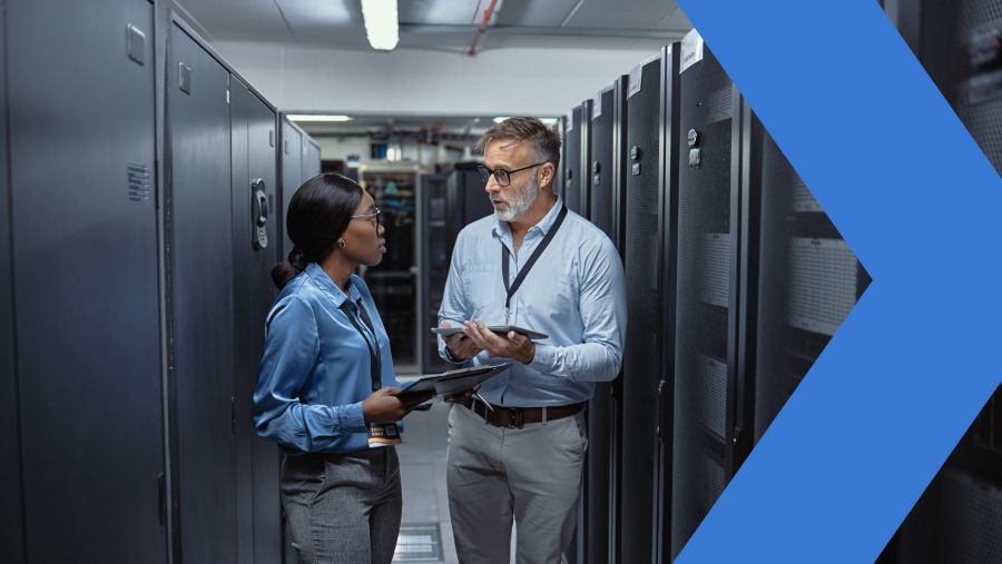 Two information security professionals having a discussion in a server room