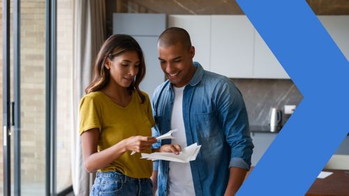 A couple looks at mail together in the kitchen