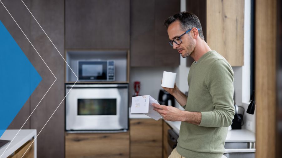 Man reading mail in his kitchen.