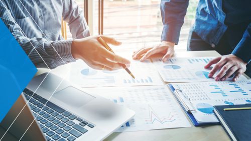 Two banking leaders looking at print-outs of graphs.