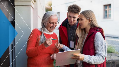 Young nonprofit employees gathering signatures from a woman at her doorstep.