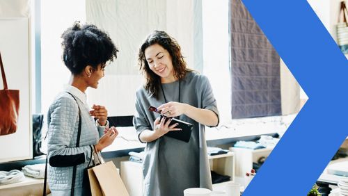 Owner processing payment for retail customer with digital tablet.