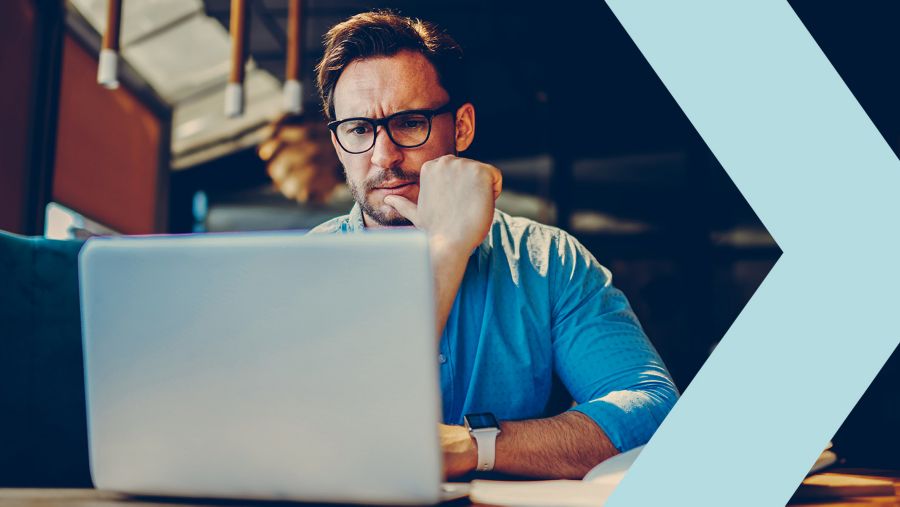 Man looking skeptical while using his laptop
