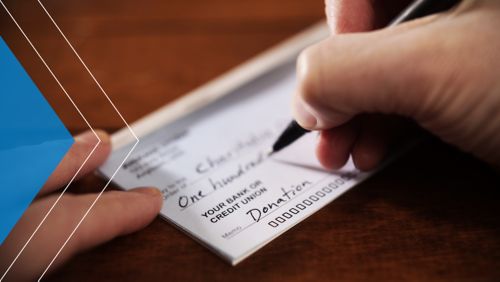 Person writing a check to a charity organization.
