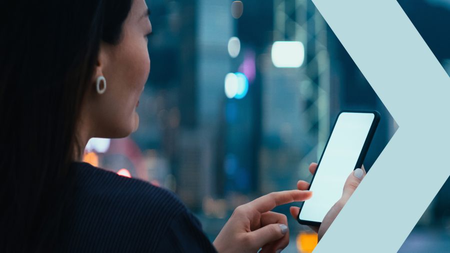 Young businesswoman checking financial stock market analysis on mobile phone infront of corporate office.