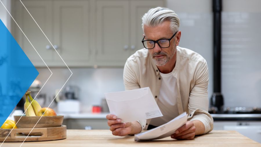 Man reading a direct mail piece in his home.