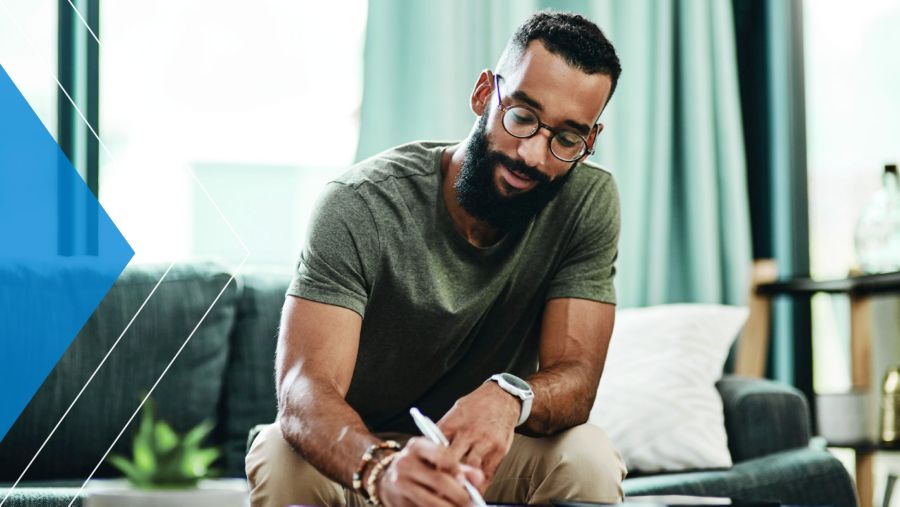 Man in his home writing on a piece of paper
