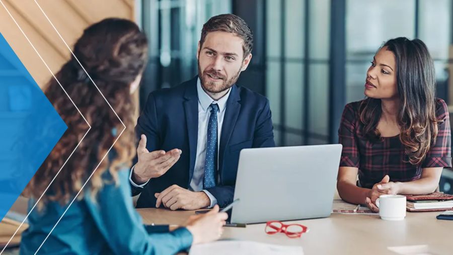 Three coworkers meeting in corporate office space. 
