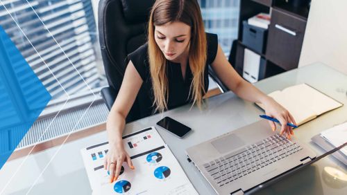 Woman working on laptop in office.