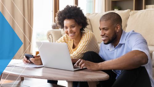 Couple on a computer reacting positively to an offer provided by their financial institutions