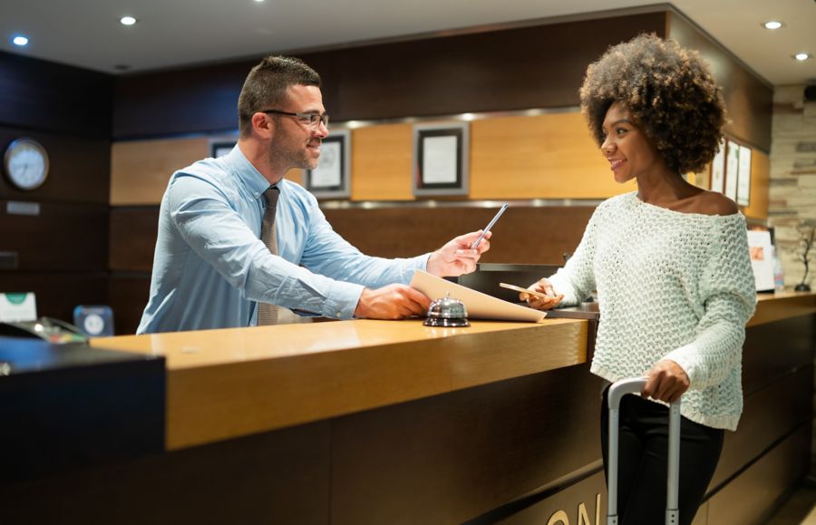 A hotel worker hands over a key card to a guest