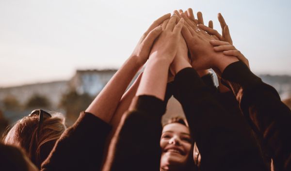 A group of people put their hands together in unity