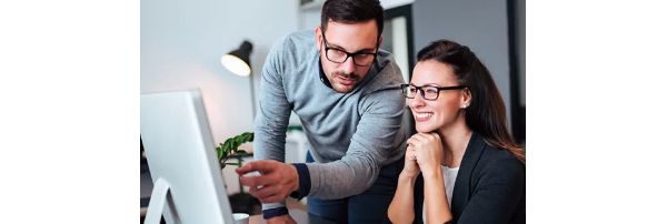 Bank marketing coworkers stare at what is being displayed on a desktop monitor.