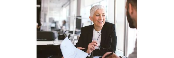Financial services workers sit at a desk and discuss a report