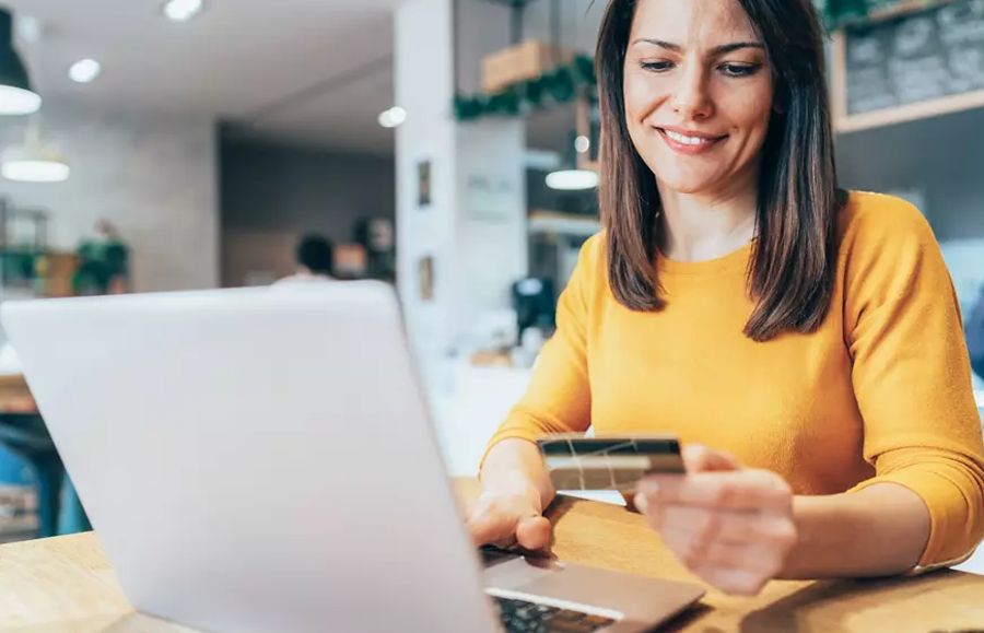 Woman paying with credit card on laptop