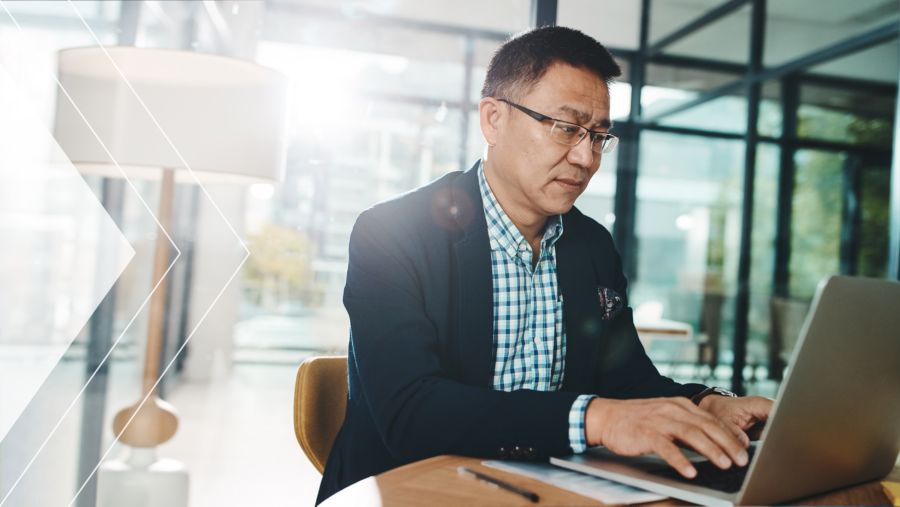 Banker sitting at his desk working on a laptop
