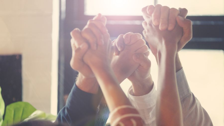 A group of hands clasped together in solidarity