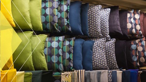Decorative pillows are shown in a home goods company's warehouse