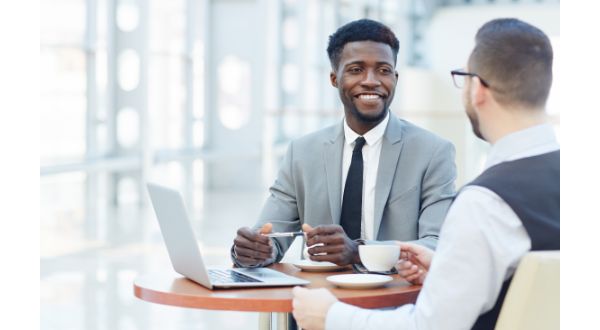 A banker sits at a table with a business owner that is interested in payment solutions.