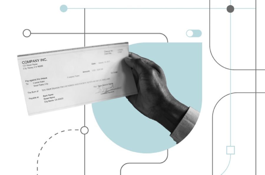 A hand holding a paper check