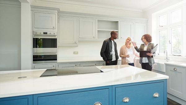A female real estate agent showing a couple a home.
