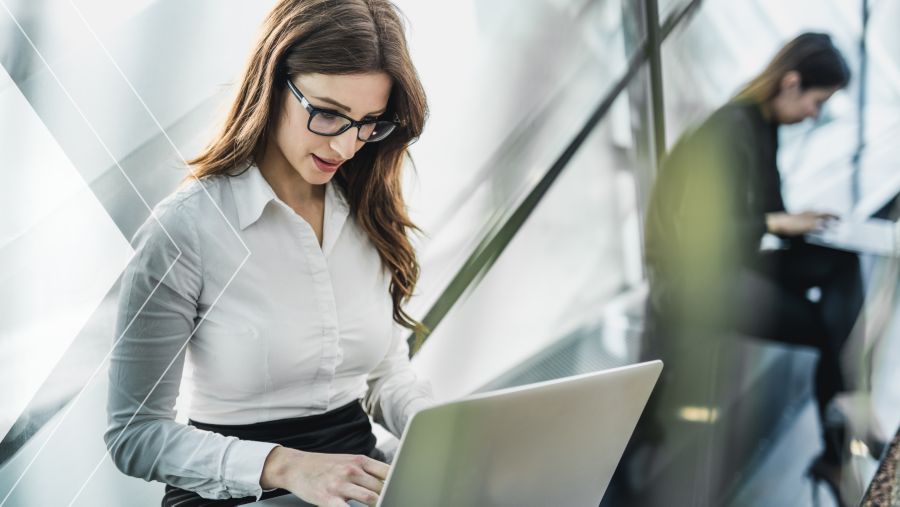 A woman in an office on a laptop 