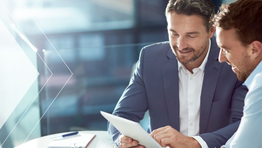 Two people using a tablet and discussing B2B electronic payments