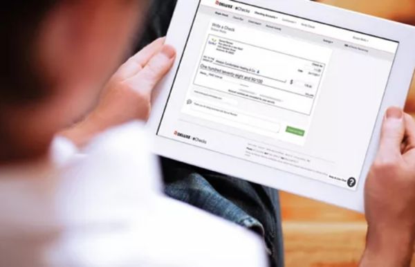 A woman holding a tablet with an echeck on the screen